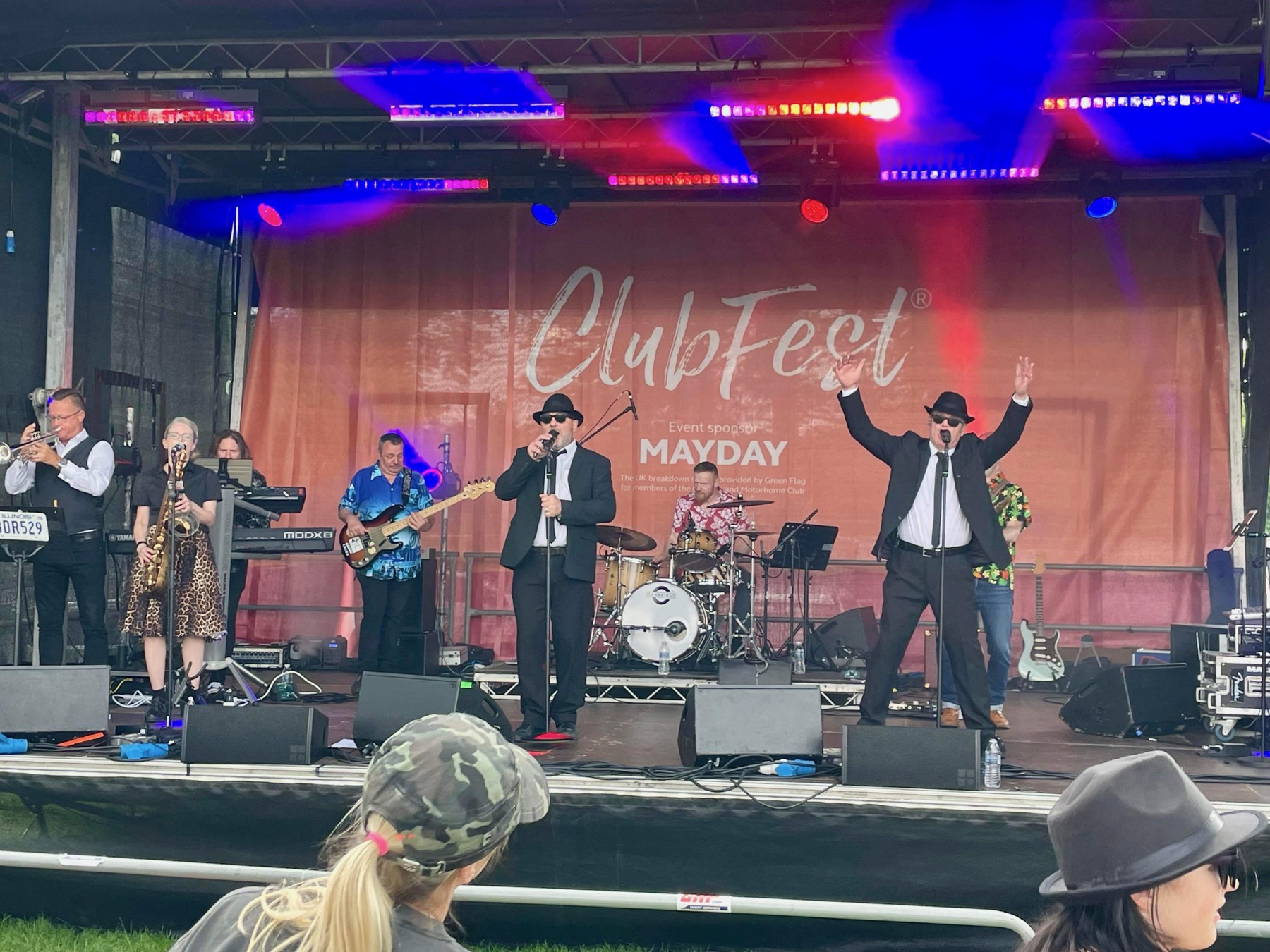 Audience members joining the band on a brightly lit festival stage