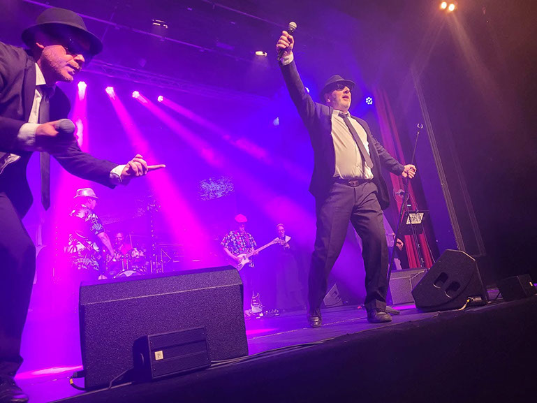 Jake and Elwood performing The All New Blues and Soul Revue theatre show under purple stage lighting