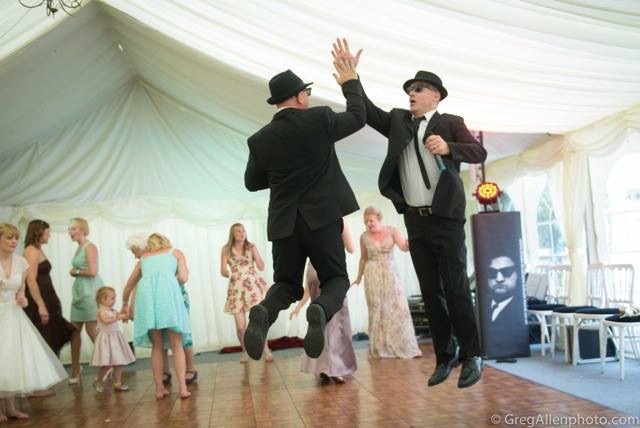 The performers jumping together on a wedding dance floor